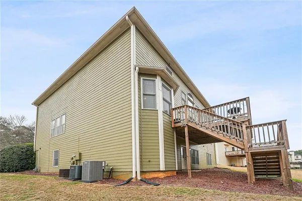 a view of a house with wooden stairs and a small yard