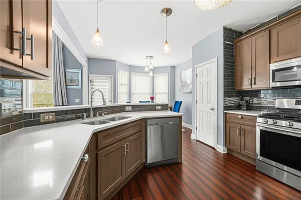 a kitchen with stainless steel appliances granite countertop a sink a stove and a refrigerator