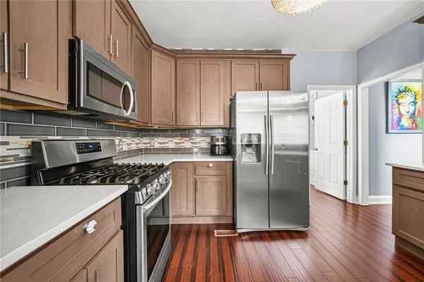 a kitchen with stainless steel appliances granite countertop a refrigerator stove and sink