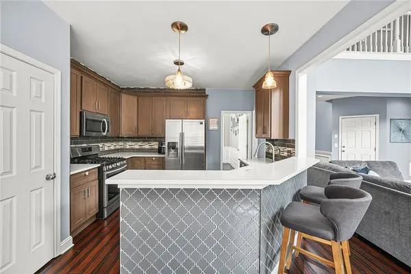 a kitchen with stainless steel appliances granite countertop a sink a stove and a refrigerator