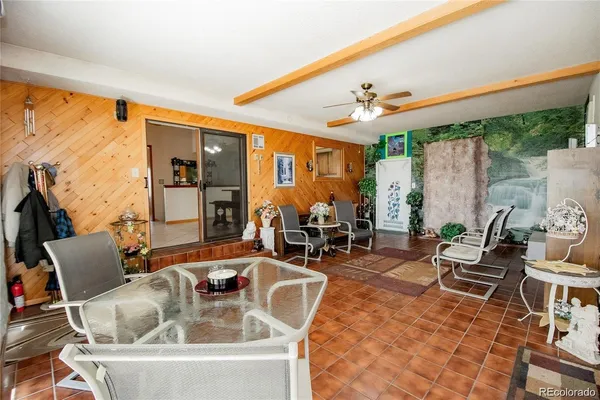 a living room with furniture a flat screen tv and floor to ceiling windows