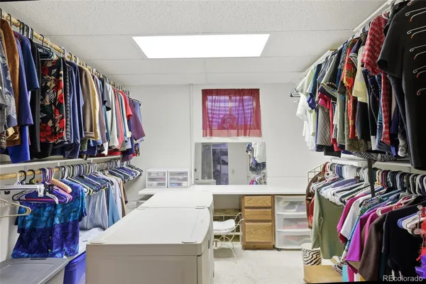 a view of walk in closet with clothes