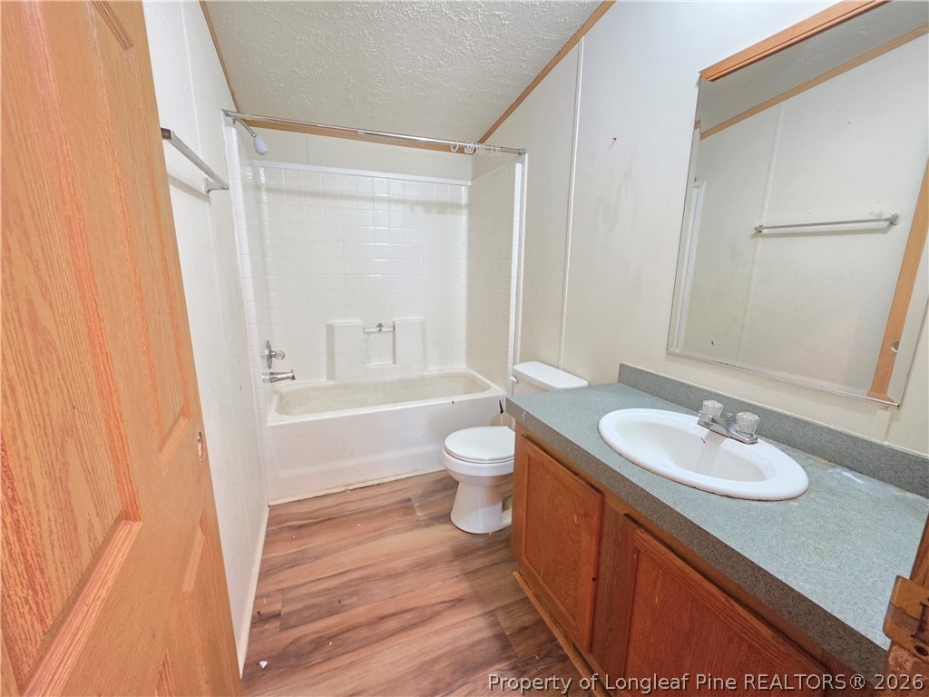 124 Franklin Road Raeford, NC 28376 - Photo 15 of 15 a bathroom with a granite countertop sink toilet a large mirror a shower and a bathtub