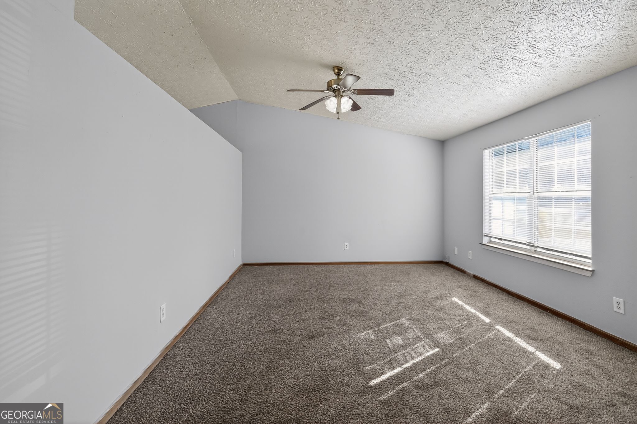 10248 Briarbay Loop Jonesboro, GA 30238 - Photo 12 of 31 an empty room with chandelier fan and windows