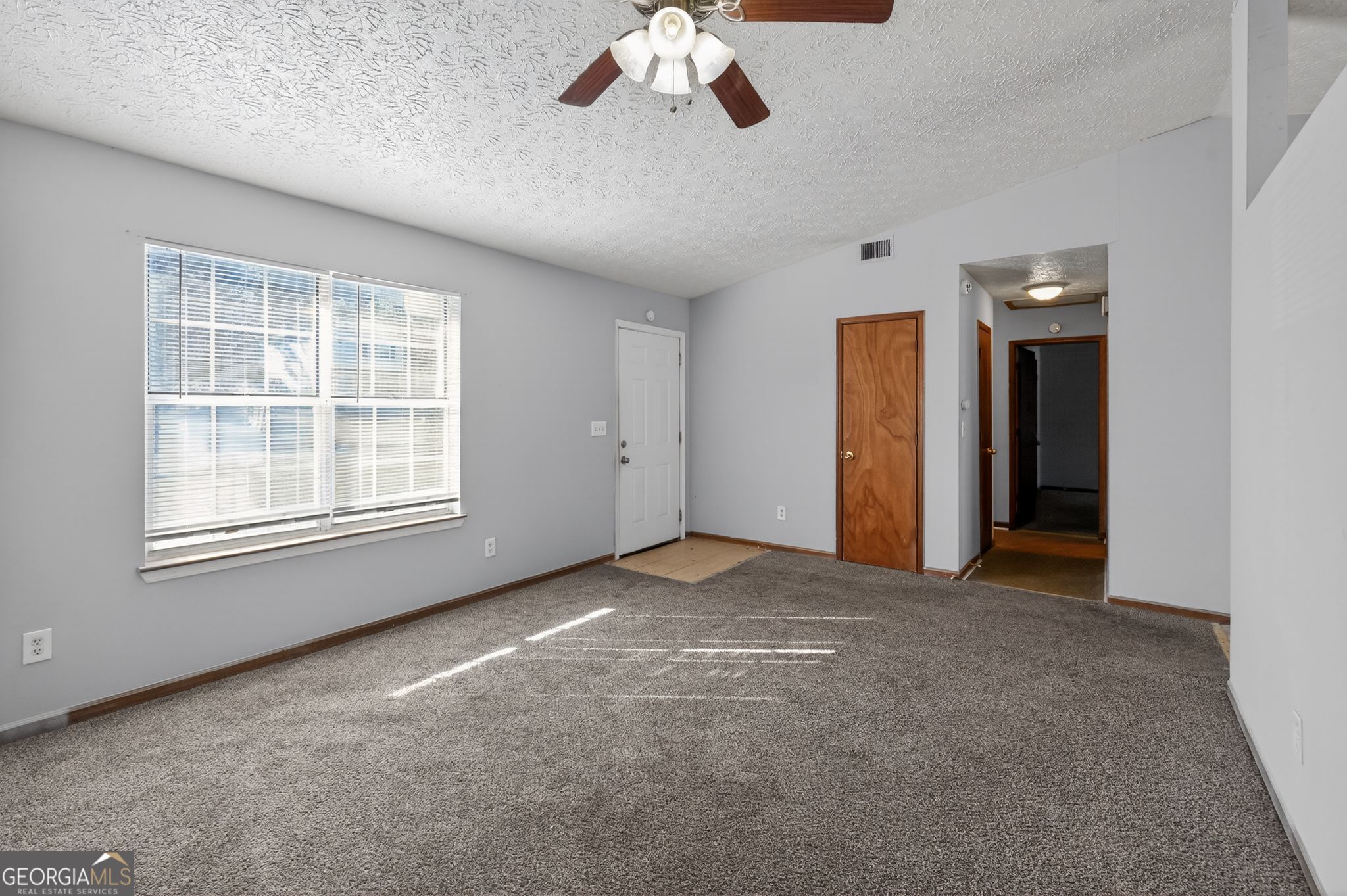 10248 Briarbay Loop Jonesboro, GA 30238 - Photo 5 of 31 an empty room with chandelier fan and windows