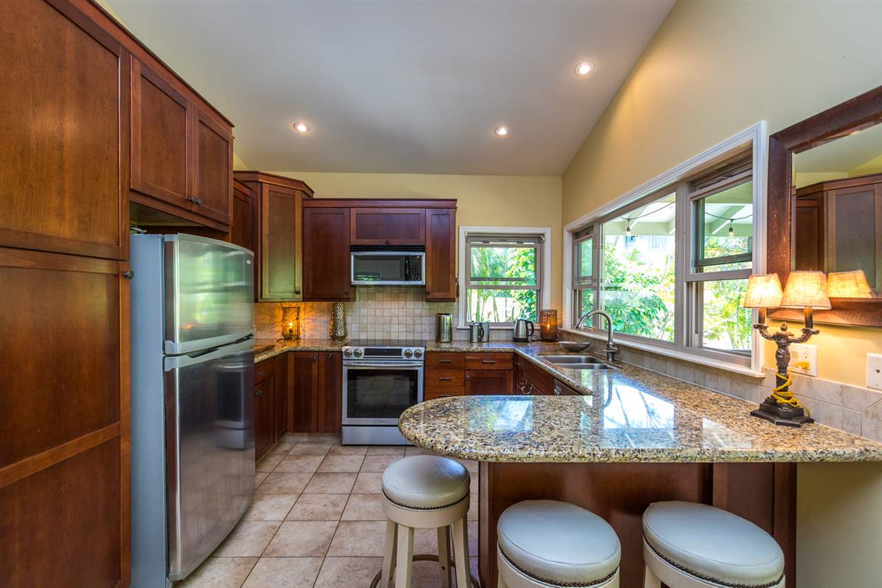 195 Mauu Place Haiku, HI 96708 - Photo 27 of 30 a kitchen with kitchen island granite countertop a sink stove and refrigerator