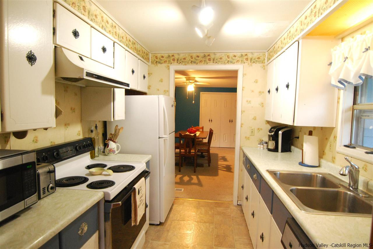 437 Scarawan Road Stone Ridge, NY 12484 - Photo 11 of 35 a kitchen with a sink stove and cabinets
