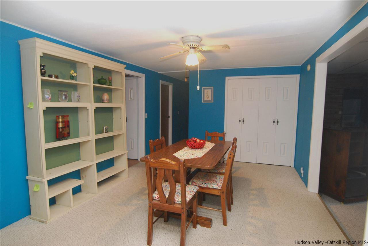 437 Scarawan Road Stone Ridge, NY 12484 - Photo 15 of 35 a dining room with furniture and a chandelier