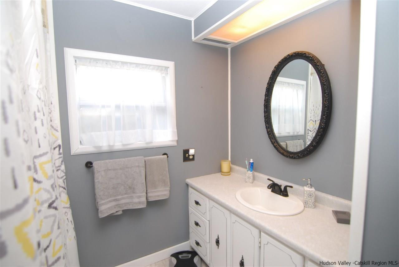 437 Scarawan Road Stone Ridge, NY 12484 - Photo 21 of 35 a bathroom with a granite countertop sink and a mirror