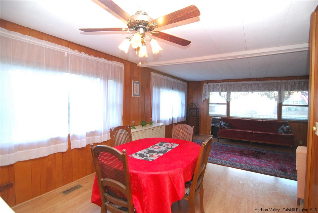 437 Scarawan Road Stone Ridge, NY 12484 - Photo 7 of 35 a living room with furniture a chandelier and a large window