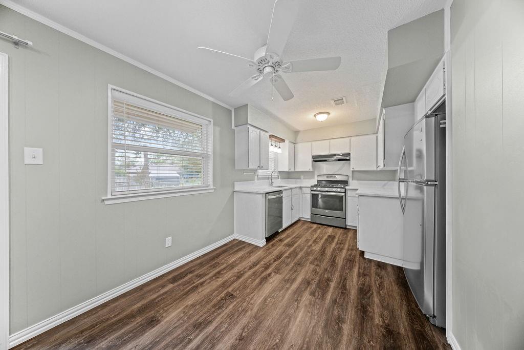 1041 Barber Street Hurst, TX 76053 - Photo 13 of 36 a kitchen with white cabinets and stainless steel appliances