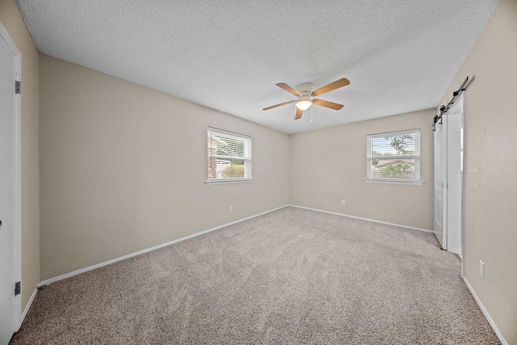 1041 Barber Street Hurst, TX 76053 - Photo 17 of 36 an empty room with windows and fan