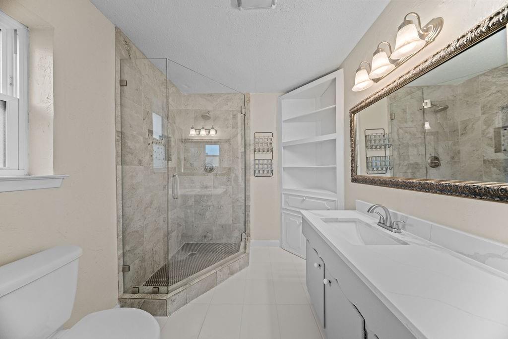 1041 Barber Street Hurst, TX 76053 - Photo 20 of 36 a bathroom with a shower sink vanity mirror and toilet