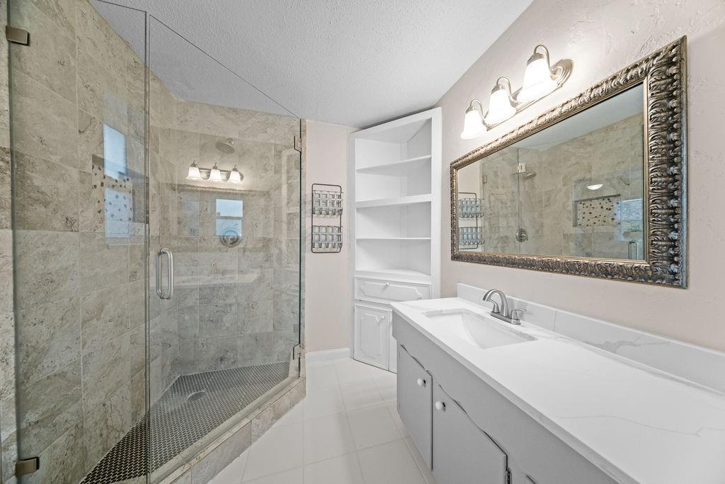 1041 Barber Street Hurst, TX 76053 - Photo 21 of 36 a bathroom with a double vanity sink mirror and shower