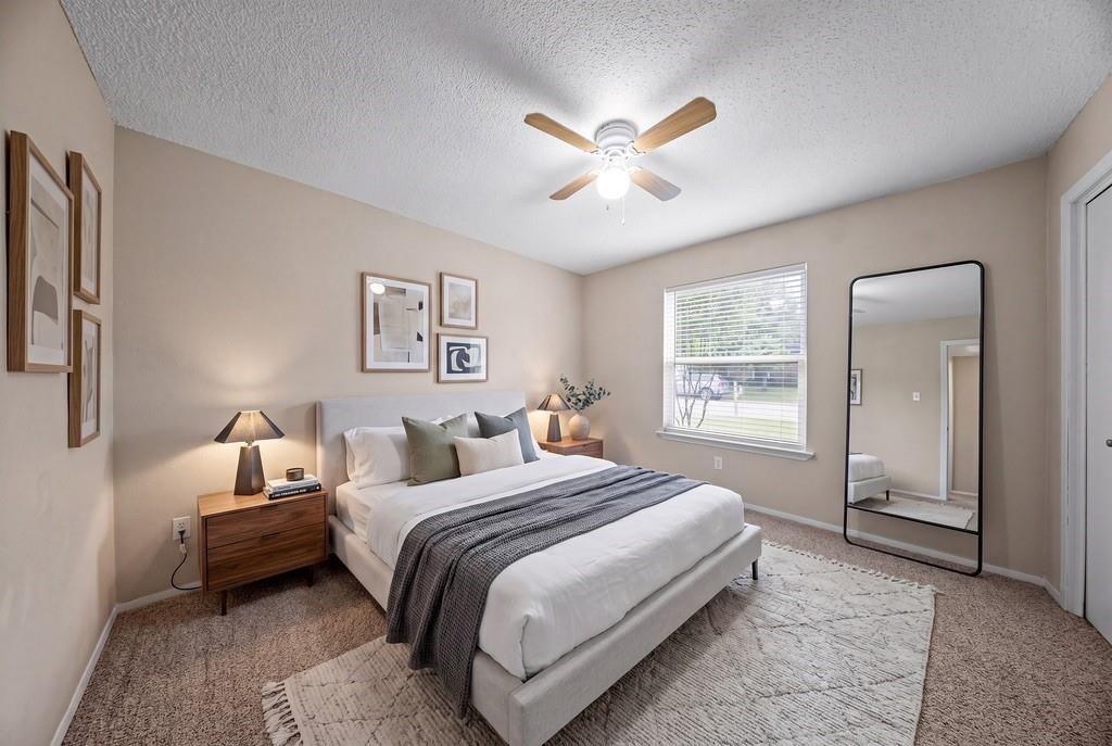 1041 Barber Street Hurst, TX 76053 - Photo 22 of 36 a bedroom with a large bed and a chandelier