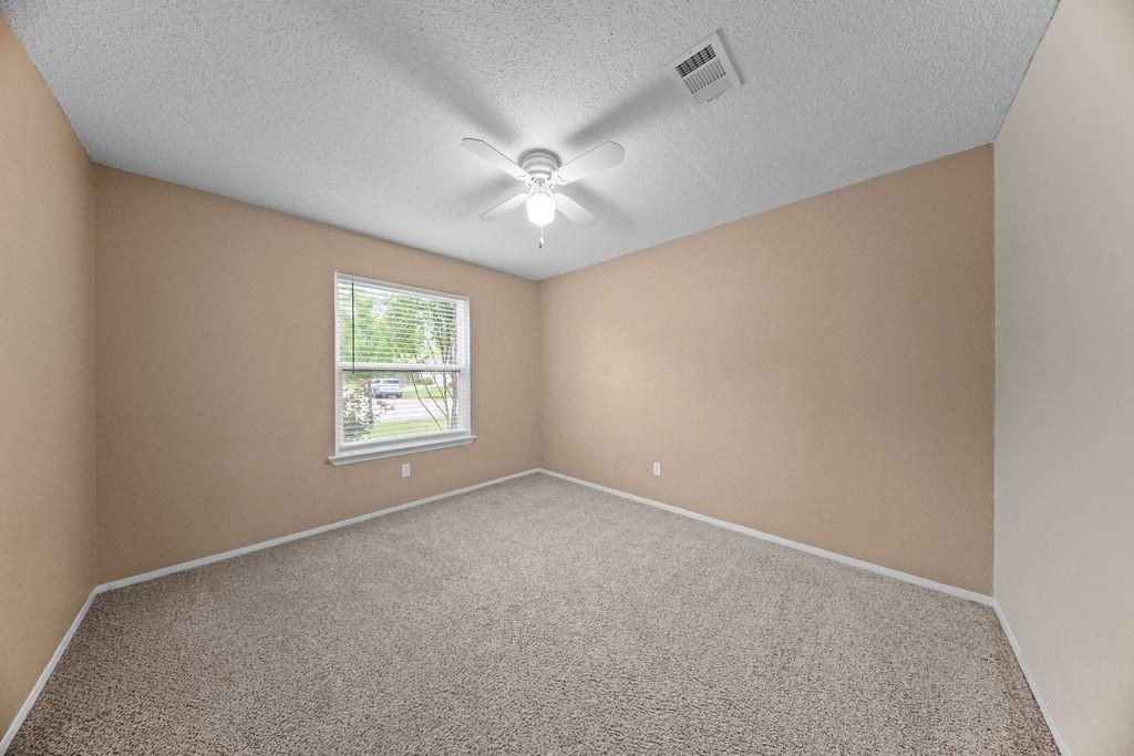 1041 Barber Street Hurst, TX 76053 - Photo 27 of 36 an empty room with a window and a fan