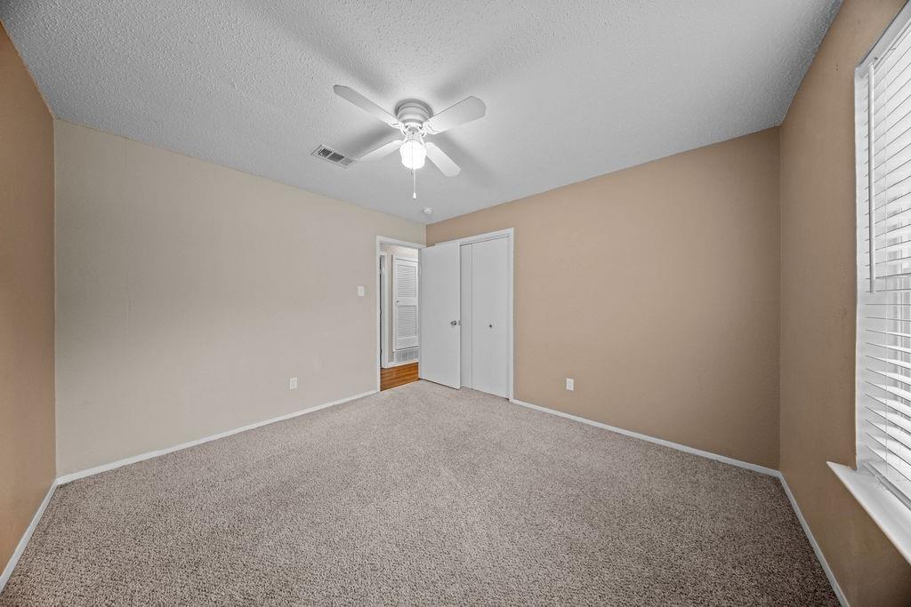 1041 Barber Street Hurst, TX 76053 - Photo 28 of 36 an empty room with windows and chandelier fan