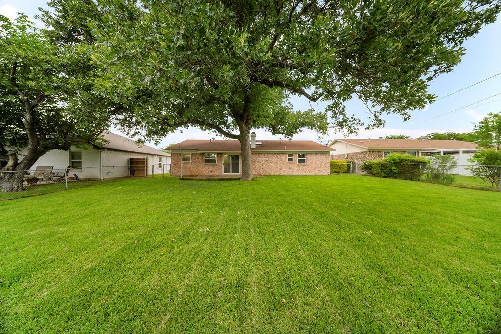 1041 Barber Street Hurst, TX 76053 - Photo 30 of 36 a view of a house with backyard and a tree
