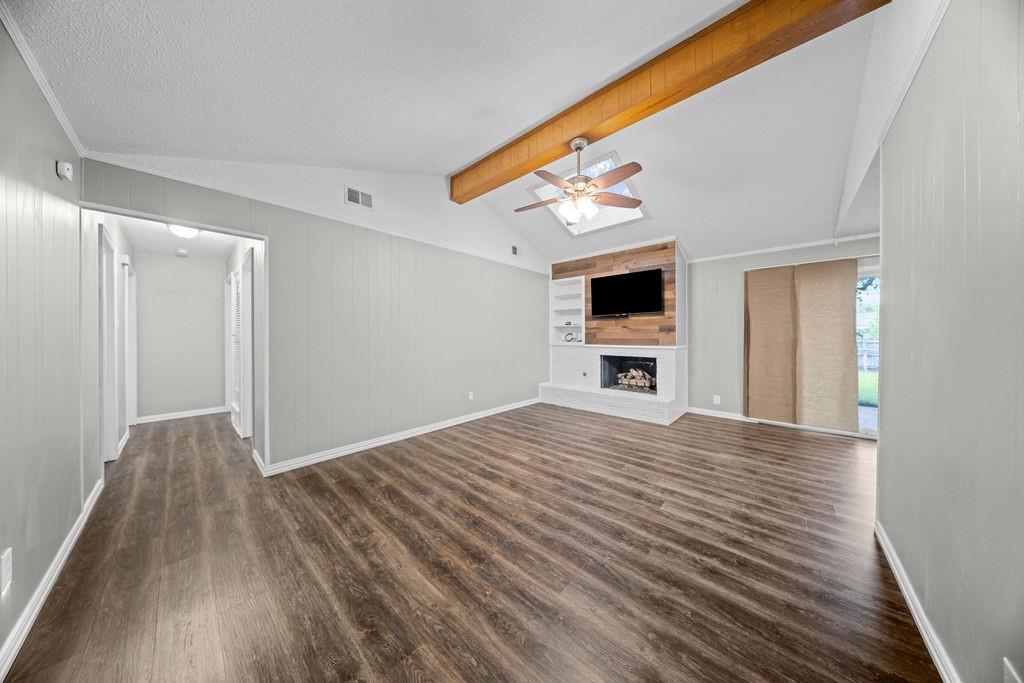 1041 Barber Street Hurst, TX 76053 - Photo 4 of 36 a view of a livingroom with wooden floor and a flat screen tv