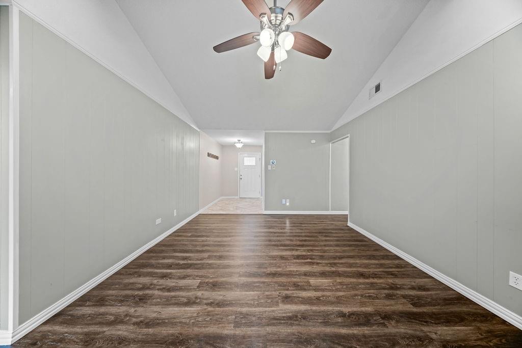 1041 Barber Street Hurst, TX 76053 - Photo 7 of 36 a view of an empty room with chandelier fan and wooden floor