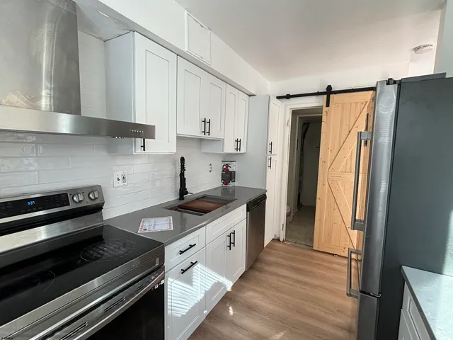a kitchen with stainless steel appliances a stove a refrigerator and cabinets