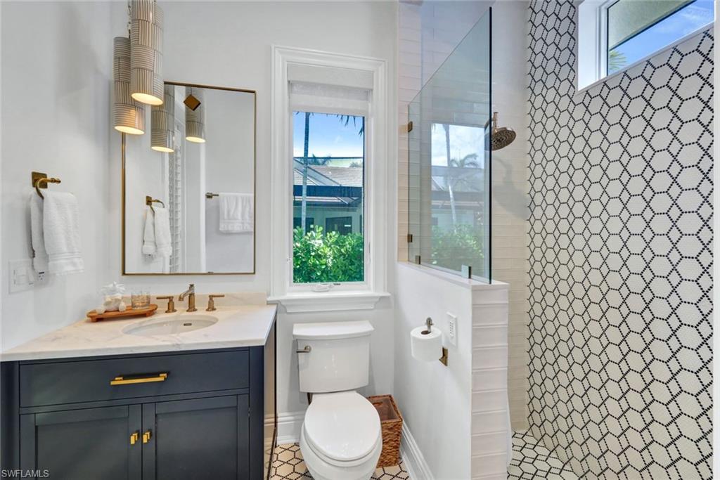 445 Putter Point Drive Naples, FL 34103 - Photo 16 of 44 a bathroom with a sink a toilet and shower