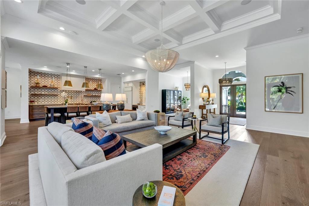 445 Putter Point Drive Naples, FL 34103 - Photo 17 of 44 a living room with furniture kitchen view and a chandelier