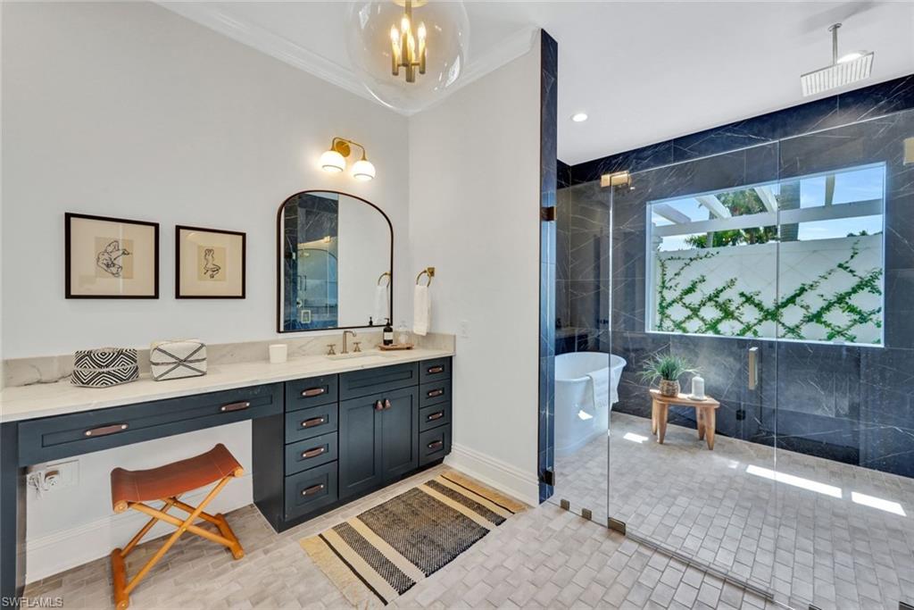 445 Putter Point Drive Naples, FL 34103 - Photo 21 of 44 a spacious bathroom with a granite countertop sink a toilet a mirror and bathtub