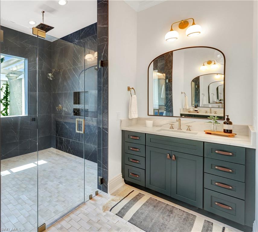 445 Putter Point Drive Naples, FL 34103 - Photo 22 of 44 a spacious bathroom with a granite countertop sink mirror and shower