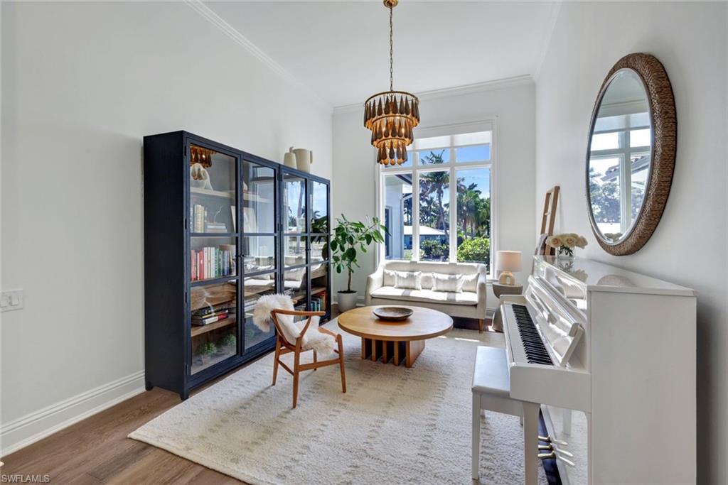 445 Putter Point Drive Naples, FL 34103 - Photo 24 of 44 a living room with furniture a rug and a chandelier
