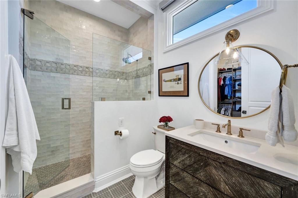 445 Putter Point Drive Naples, FL 34103 - Photo 31 of 44 a bathroom with a toilet sink and mirror