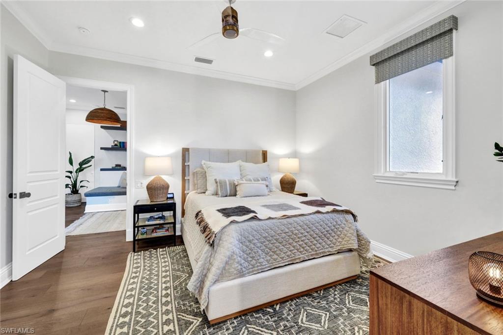 445 Putter Point Drive Naples, FL 34103 - Photo 32 of 44 a bedroom with a bed and wooden floor