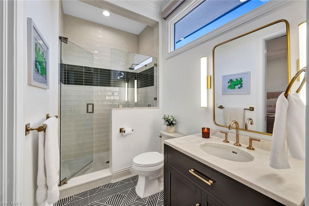 445 Putter Point Drive Naples, FL 34103 - Photo 33 of 44 a bathroom with a granite countertop shower sink vanity mirror and toilet