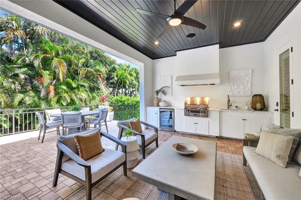 445 Putter Point Drive Naples, FL 34103 - Photo 36 of 44 a view of a porch with furniture and a grill