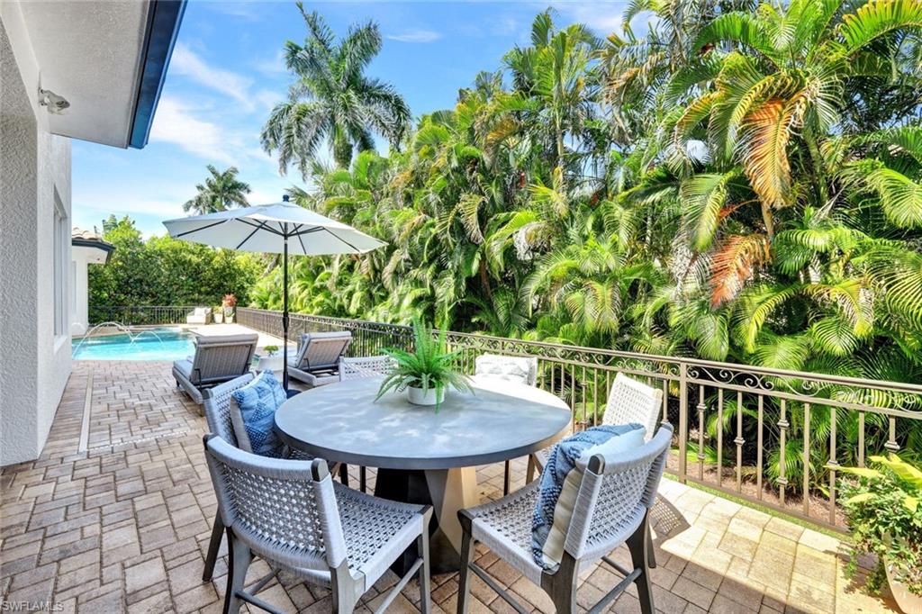 445 Putter Point Drive Naples, FL 34103 - Photo 38 of 44 a patio with a patio table and chairs
