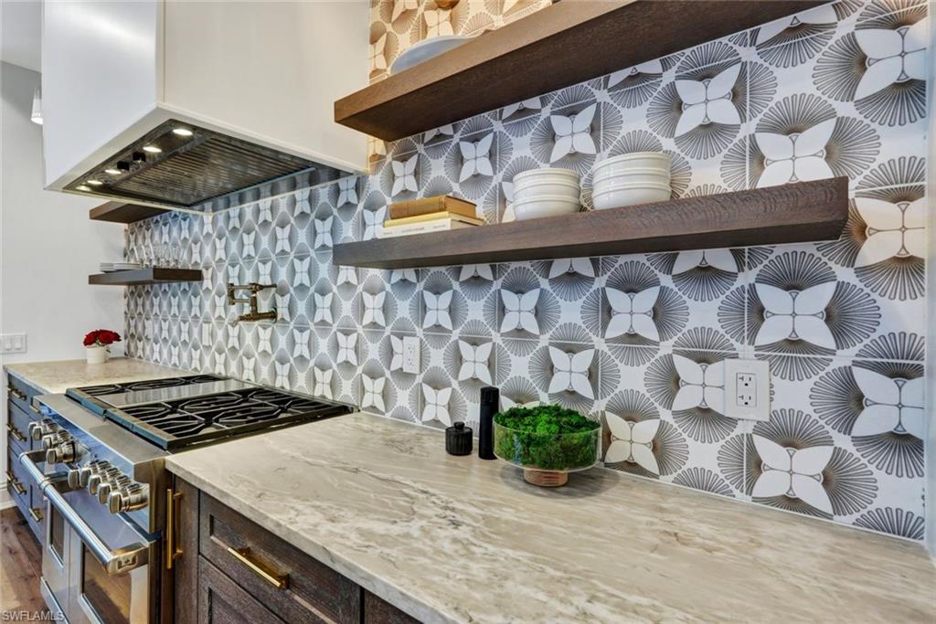 445 Putter Point Drive Naples, FL 34103 - Photo 10 of 44 a kitchen with a stove and wooden cabinets