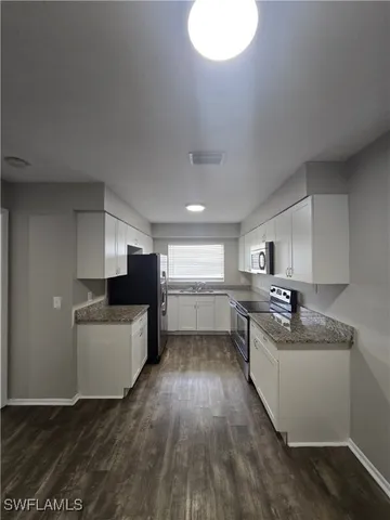 a kitchen with a sink cabinets and wooden floor