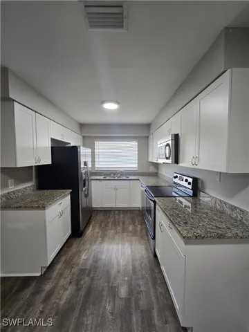 a large kitchen with a stove top oven and sink