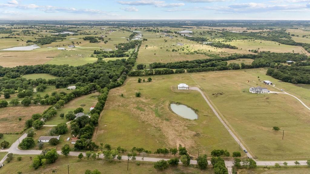 1161 Alsdorf Road Ennis, TX 75119 - Photo 4 of 28 Expansive rural landscape featuring a private pond, multiple residential structures, wooded areas, and a network of unpaved roads