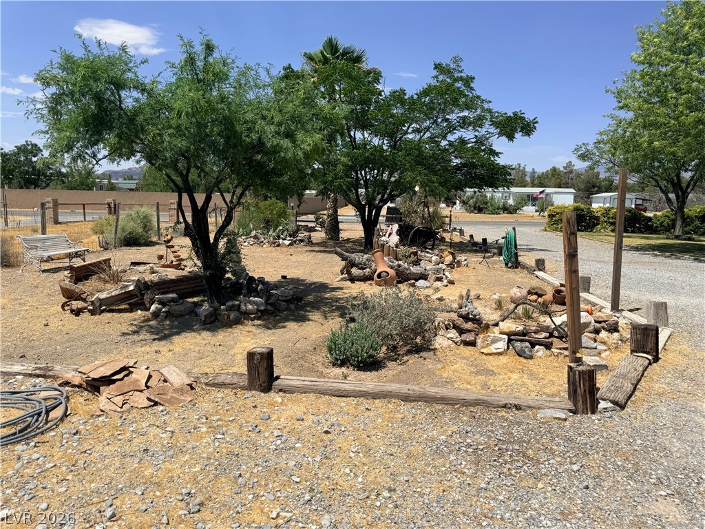 1391 West Dyer Road Pahrump, NV 89048 - Photo 19 of 50 Mature trees and desert-inspired landscaping adorn this private outdoor space.