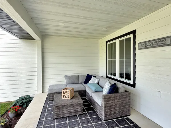 a living room with furniture a flat screen tv and a window