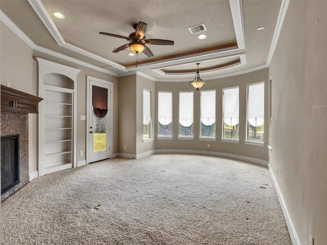 a view of an empty room with a fireplace and a window