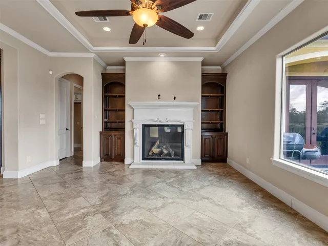 a view of an empty room with a fireplace and a window
