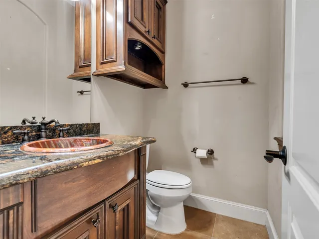 a bathroom with a granite countertop sink a toilet and a mirror