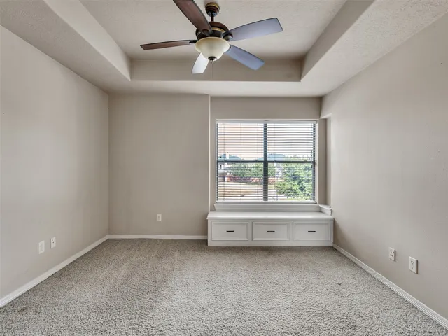 an empty room with a window and a ceiling fan