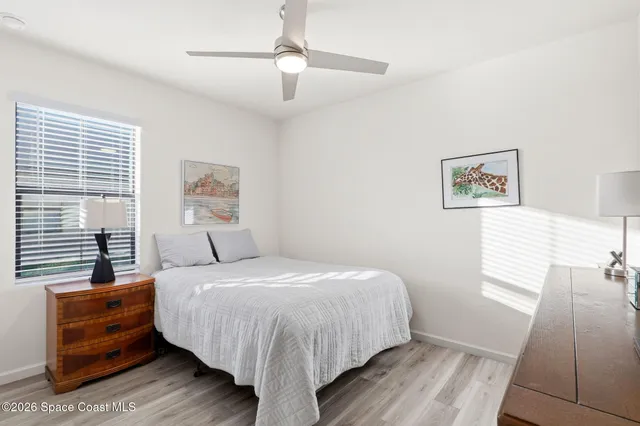 a bedroom with a bed and a dresser next to a window