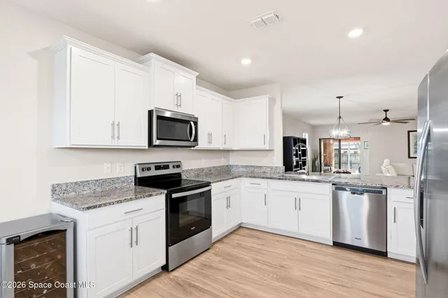 a kitchen with granite countertop a sink and steel appliances
