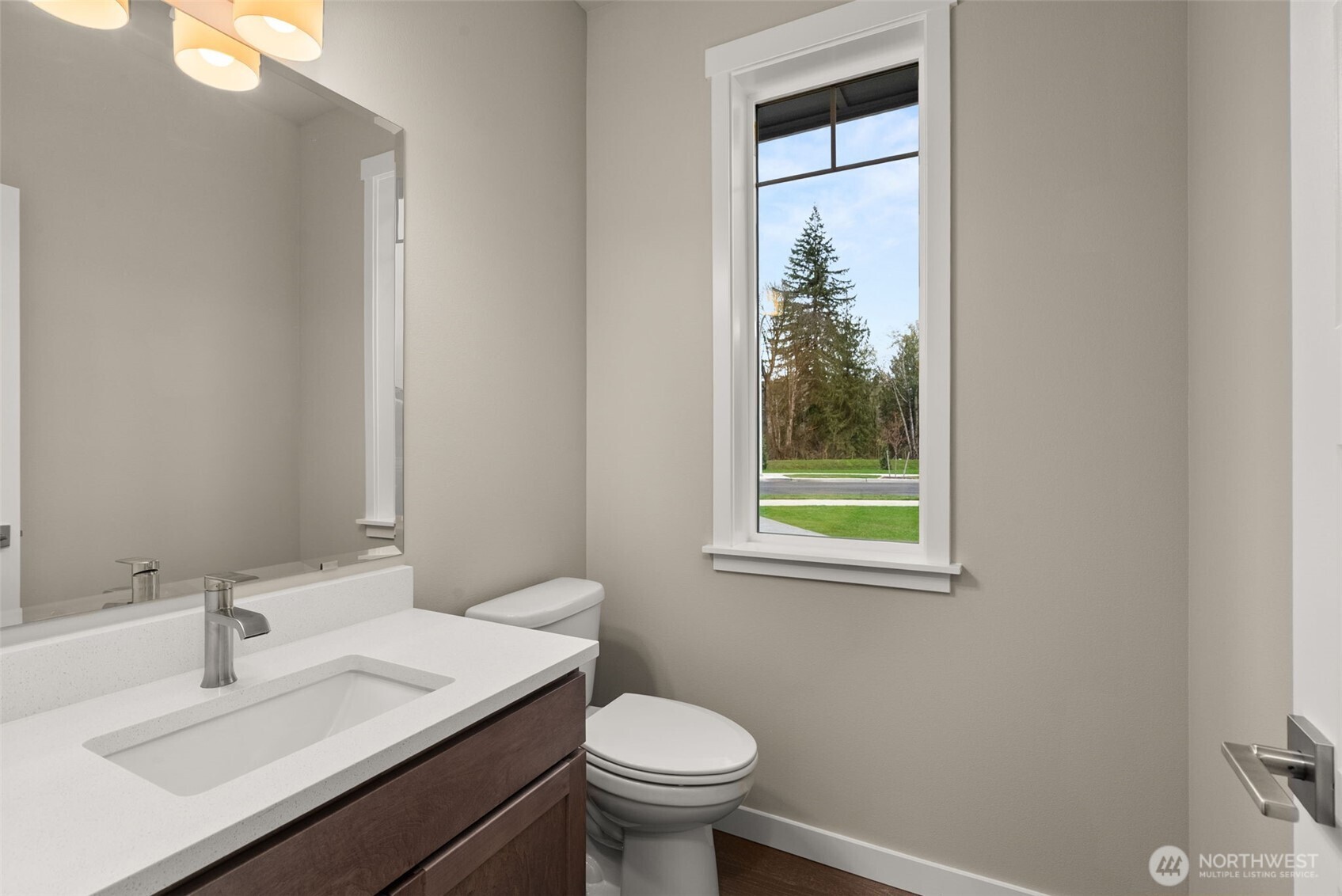 5654 Mimi Street Southwest Tumwater, WA 98512 - Photo 14 of 38 a bathroom with a granite countertop toilet a sink a mirror and a window