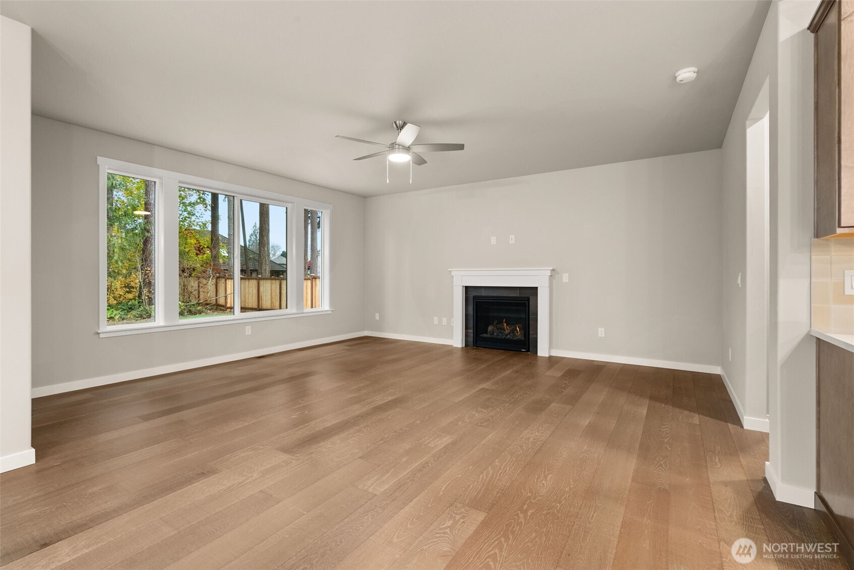 5654 Mimi Street Southwest Tumwater, WA 98512 - Photo 5 of 38 wooden floor fireplace and windows in an empty room