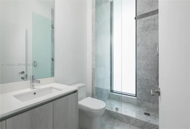 a bathroom with a sink toilet and a mirror